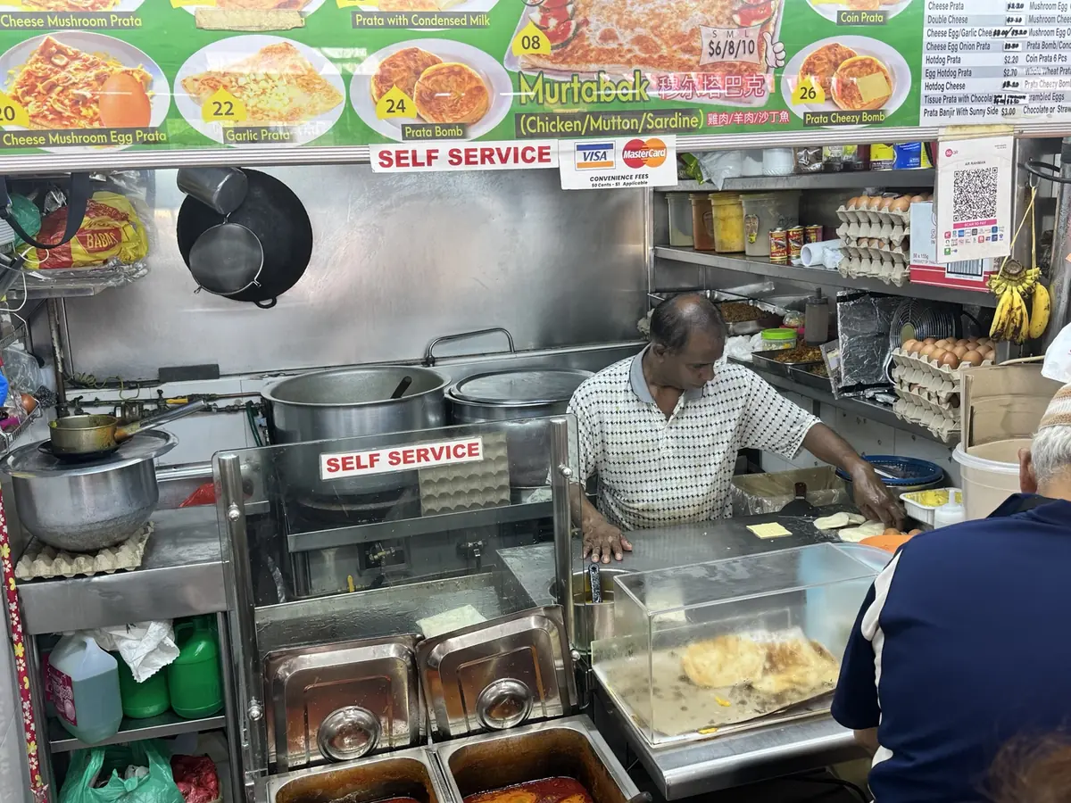 A hawker preparing prata at a Singapore food stall